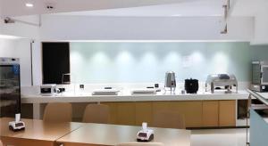 una gran cocina con mesas y sillas en una habitación en City Comfort Inn Shaoyang Wugang, en Wugang