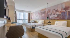 ein Hotelzimmer mit zwei Betten und einem Tisch in der Unterkunft City Comfort Inn Lijiang Ancient Town in Lijiang