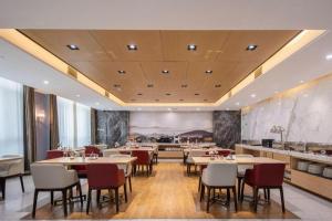 a dining room with tables and chairs in a restaurant at Jinjiang Inn Select Heze Wanxiang Plaza Guiling Road in Zhaolou