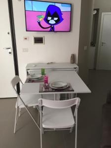 a white table and chair with a tv on the wall at B&B Belvedere in Cerignola