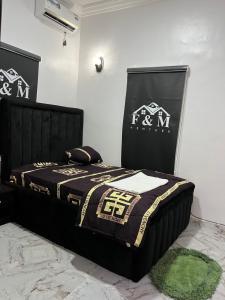 a bedroom with a bed with a black and white comforter at Fm homes in Lekki