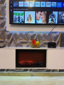 a tv on a wall with a fireplace at Fm homes in Lekki