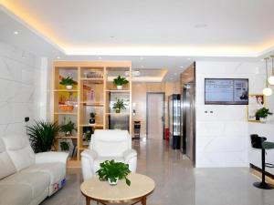 a living room with a white couch and a table at Green Tree Inn Express Xingtai Guangzong Development Zone Xingqing Road in Guangzong