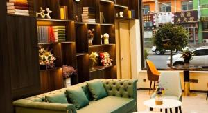 a living room with a green couch and a table at Shell Hotel Shanxi Xinzhou Wuning County Fengwu Square in Ningwu