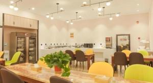 a dining room with a table and chairs and a kitchen at Green Tree Inn Express Hefei Yungu Road Linhu Community in Hefei