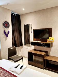 a hotel room with a bed and a flat screen tv at Sunrise cave in Surat