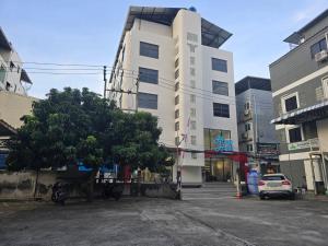 a parking lot in front of a white building at House Hotel Pattaya Sai 3 in Pattaya Central