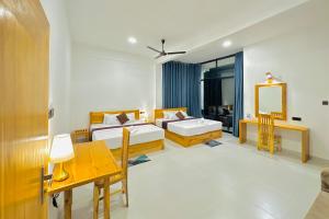 a room with two beds and a table and a mirror at Gamagedara Resort in Dambulla