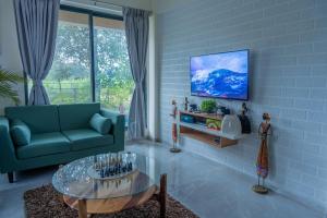 a living room with a couch and a tv on a wall at Villa 29 - 3BHK Villa with Private Pool in Khopoli in Pali