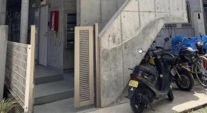 a motorcycle parked next to a building with a staircase at NOMAD Kiara City in Matsudo