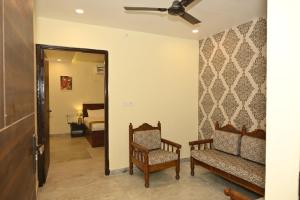 Una sala de estar con un sofá y un espejo. en SHAURYAAKSH HOTEL & Home stay, en Jaipur