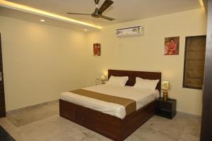 Un dormitorio con una cama y un ventilador de techo. en SHAURYAAKSH HOTEL & Home stay, en Jaipur