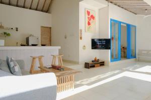 un salon avec un canapé et une télévision dans l'établissement Beji Ayu Seminyak - 1 Bedroom Private Villa, à Seminyak