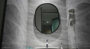 a bathroom with a mirror and a sink at Borrman Hotel Ji'an Railway Station Jinggangshan University in Ji'an