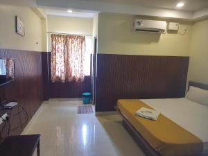 a small bedroom with a bed and a window at Santhosh Inn in Velankanni