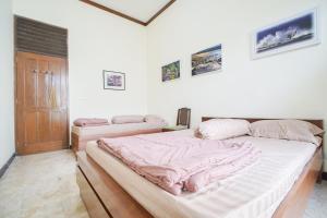 En eller flere senge i et værelse på Omah Noes Homestay Jogja