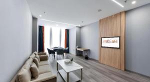 XiwujieqiaoにあるBorrman Hotel Jiangyin Zhouzhuangのソファとテーブルのあるリビングルーム