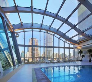 a pool in a building with a view of the city at City Hotel Shanghai in Shanghai