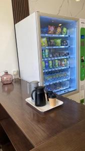 an open refrigerator with two coffee cups on a plate at آنتري للشقق المخدومة in Buraydah