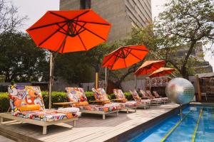 a row of chairs with umbrellas next to a pool at The Park New Delhi in New Delhi