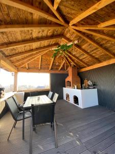 eine Terrasse mit einem Tisch und Stühlen auf dem Dach in der Unterkunft EleS Chalet in Brebu