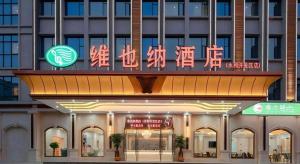 a building with neon signs on the front of it at Vienna Hotel Guangzhou Yonghe Development Zone in Guangzhou