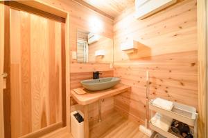 baño con lavabo en una pared de madera en 山小屋吉丁, en Ukiha