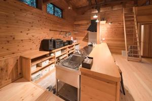 una cocina en una cabaña de madera con fregadero en 山小屋吉丁, en Ukiha