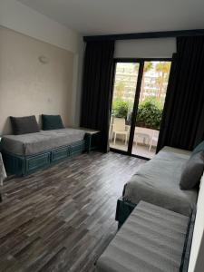 a hotel room with two beds and a balcony at Casa Clara Apartment mit Meerblick direkt am Strand in Chlorakas +18 photos