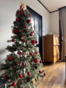 a christmas tree with ornaments on it in a room at ''内装フルリフォーム''一棟貸し l 千歳空港まで30分 l HOKKAIDO l 椴松Todomatsu in Yuni