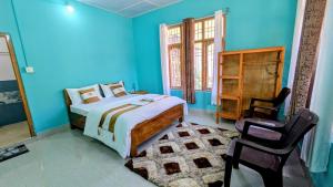 a bedroom with blue walls and a bed and a chair at Accomoon River Side Cottages in Dirang Dzong +27 photos