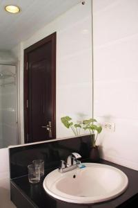 een badkamer met een witte wastafel en een spiegel bij City Center Hotel in Baguio