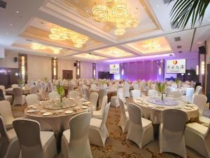 运城Yuncheng Jianguo Hotel的摆放着白色桌椅的宴会厅 更多212张照片