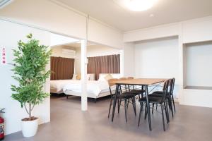a room with a table and chairs and a bed at rice house in Kumamoto