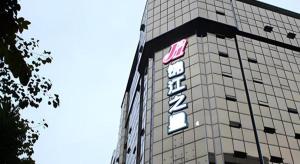 a building with a sign on the side of it at Jinjiang Inn Meizhou Binfang Avenue Keduhui Commercial Plaza in Meizhou