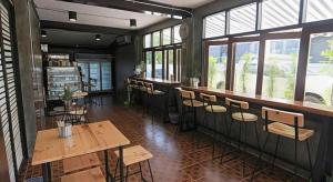 een restaurant met houten tafels, stoelen en ramen bij BAANKONPAI in Pai