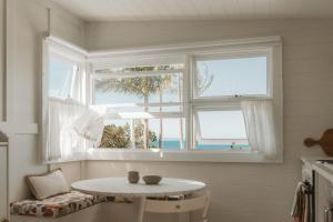 a table and chairs in a room with a window at George @ Ethel & Odes in Bundeena