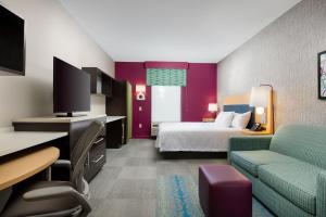 a hotel room with a bed and a couch at Home2 Suites by Hilton Ridgeland in Ridgeland