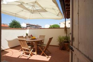 un patio con mesa, sillas y sombrilla en Casa Cosi Masaccio, en Florencia