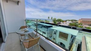 Un balcón con mesa y sillas y el mar. en The Sunset Exclusive Top Floor, en Chonburi