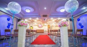 a banquet hall with a red carpet and blue balloons at Manee Sangkha Hotel in Sangkha