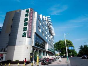 un edificio con motocicletas estacionadas frente a él en GreenTree Inn Zhangjiagang Yangshe Old Street Stadium, en Zhangjiagang