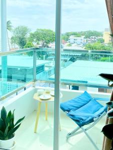 Una habitación con una mesa y sillas en un balcón. en The Sunset Exclusive Top Floor, en Chonburi