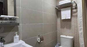 een badkamer met een wit toilet en een wastafel bij WE Hotel Kowloon in Hong Kong