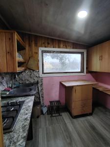 Una pequeña cocina con fregadero y ventana. en Moises, en Ureki