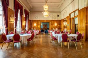 a banquet hall with white tables and red chairs at Haparanda Stadshotell in Haparanda