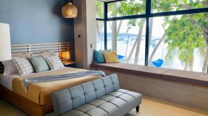 长滩岛Marzon Beach Resort - Boracay的一间卧室配有一张床,窗户配有沙发