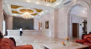 ein Wohnzimmer mit einem Kronleuchter und ein Mann, der in einer Lobby steht in der Unterkunft Vienna Hotel Shenzhen Bao'an Airport Taoyuanju Pingluanshan Metro Station in Xin'an