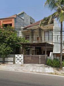 una casa con una valla y una palmera en Villa Hayoo marem, en Sukowati