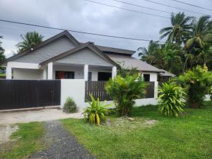 een huis met een hek voor een tuin bij Villa 820 in Pacific Harbour